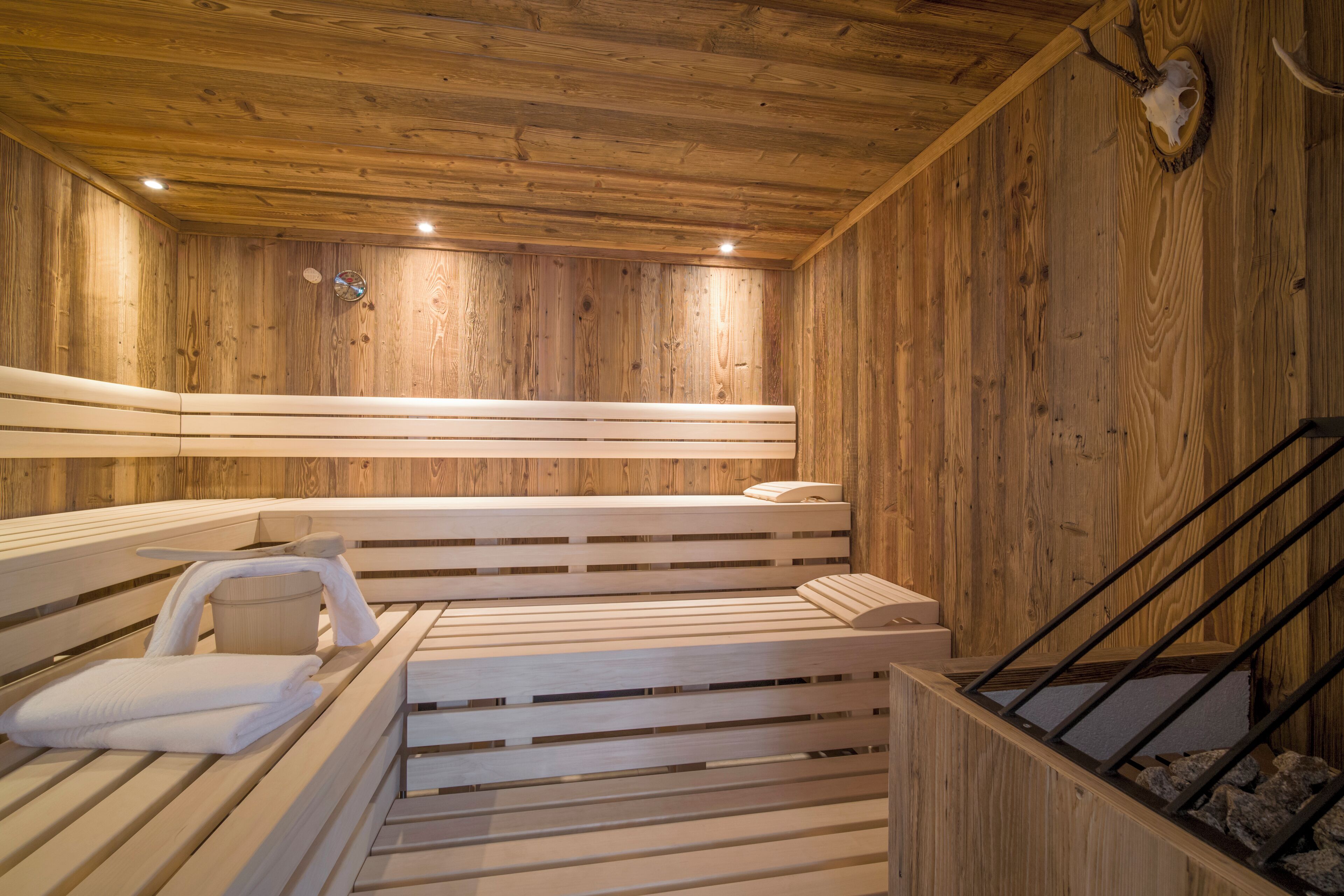 Una sauna de madera con bancos y una pared de piedra.