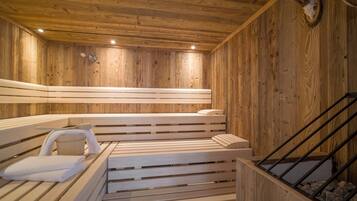 Una sauna de madera con bancos y una pared de piedra.