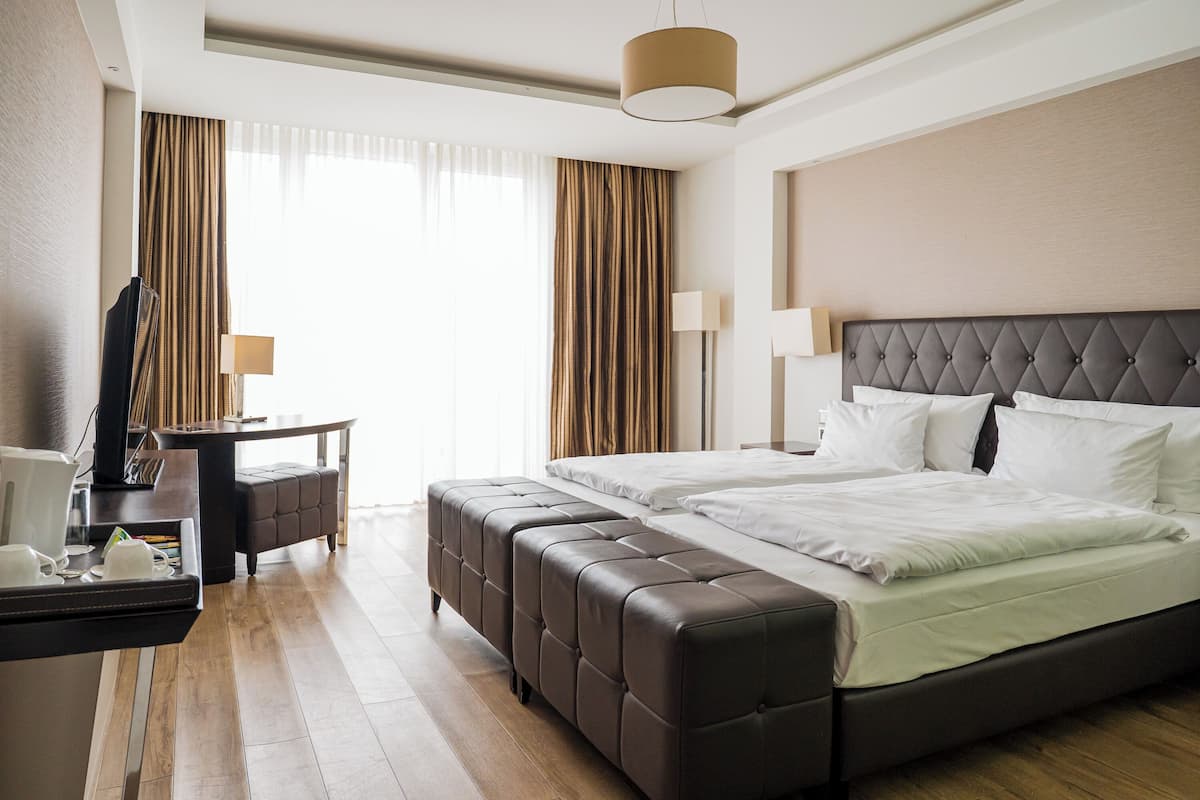 Een hotelkamer met een groot bed, een bureau met lamp en een televisie.