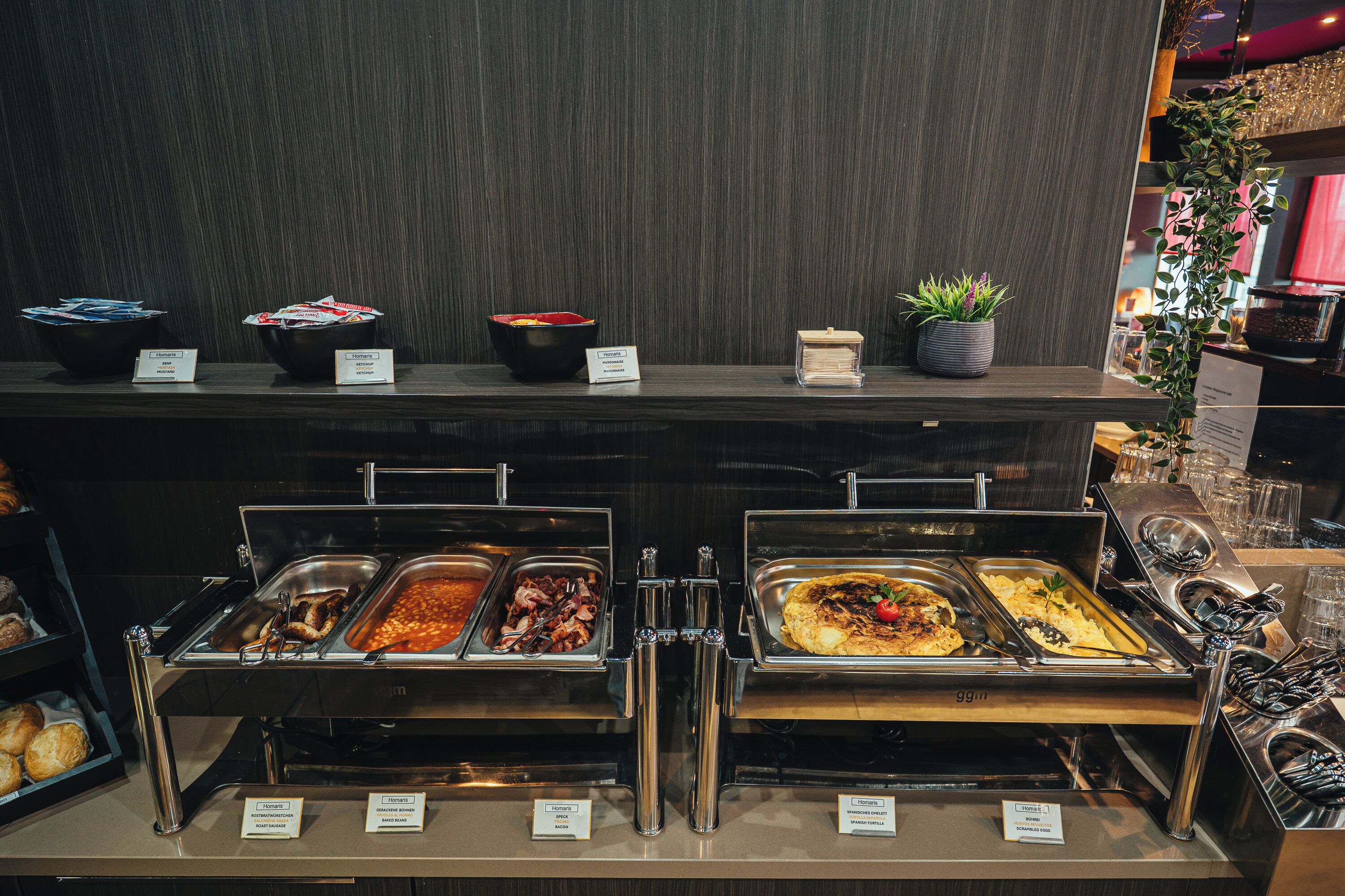 Un buffet proposant une variété de plats, chacun étant accompagné d’une étiquette indiquant son nom.