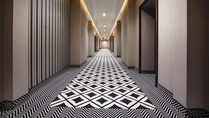 Un pasillo largo y estrecho con piso estampado e iluminación empotrada.