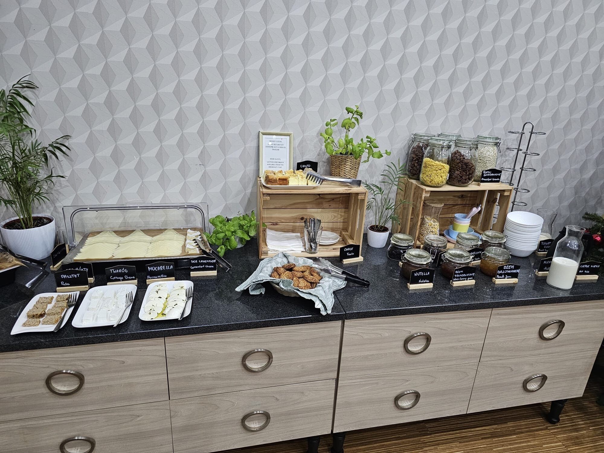 A buffet setup with labeled food items and a variety of condiments.