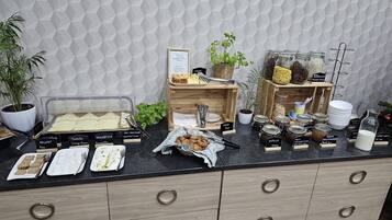 A buffet setup with labeled food items and a variety of condiments.