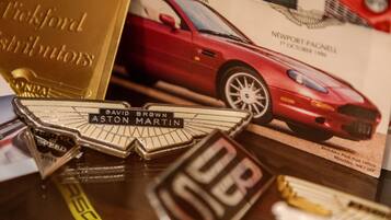 A car magazine cover with a red sports car, a gold plaque, and a silver trophy.