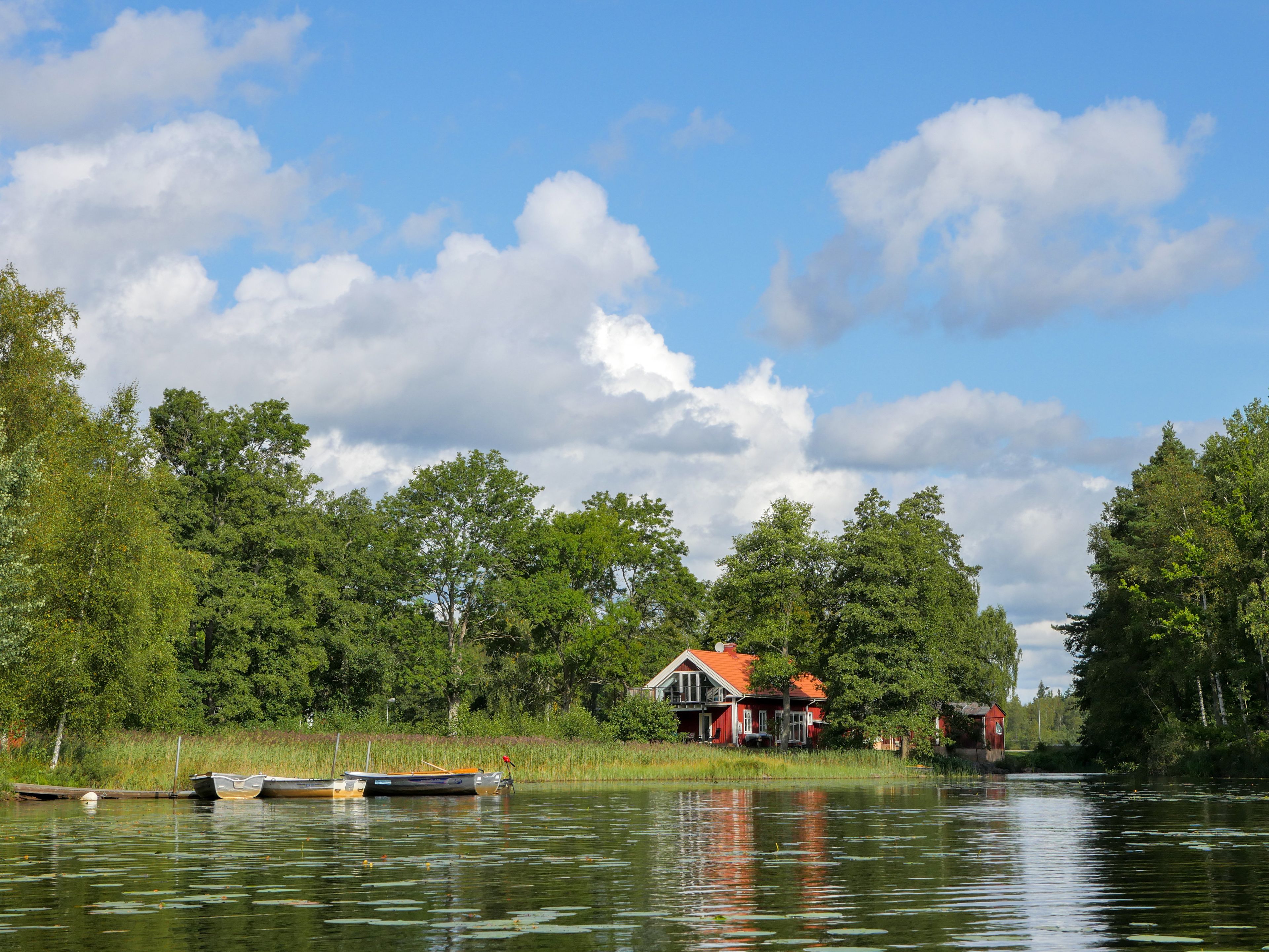 Ein Anwesen am Seeufer mit Haus, Steg und Booten.