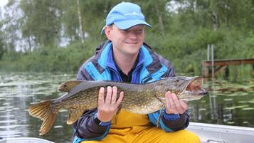 Eine Person hält einen Fisch in einem Boot.