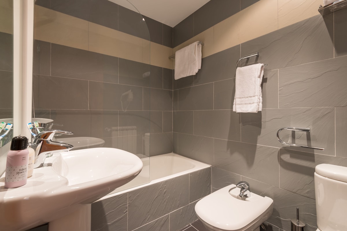 Une salle de bain moderne avec une baignoire, deux lavabos et des toilettes.