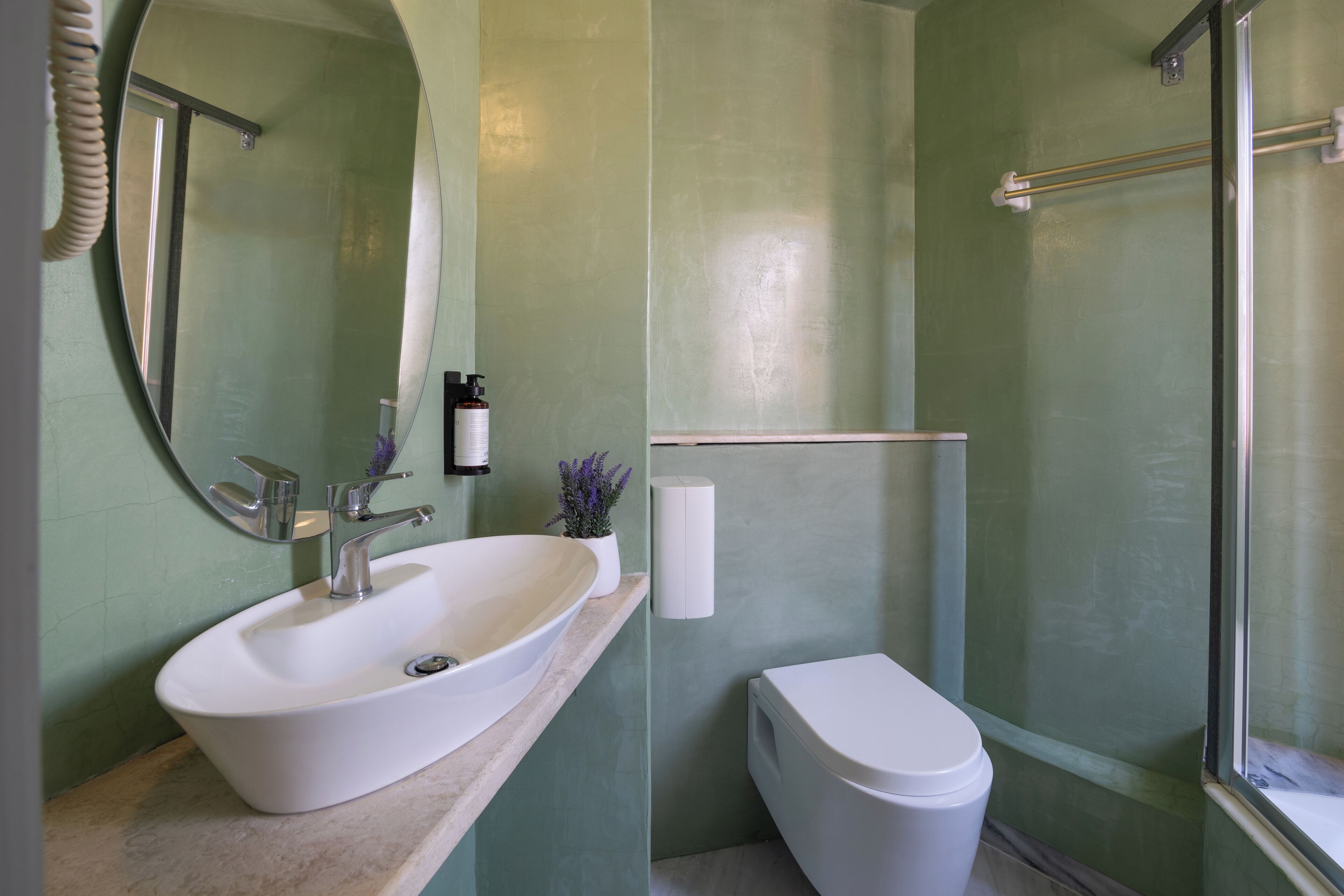 Une salle de bain avec un lavabo blanc, des toilettes et un espace douche.