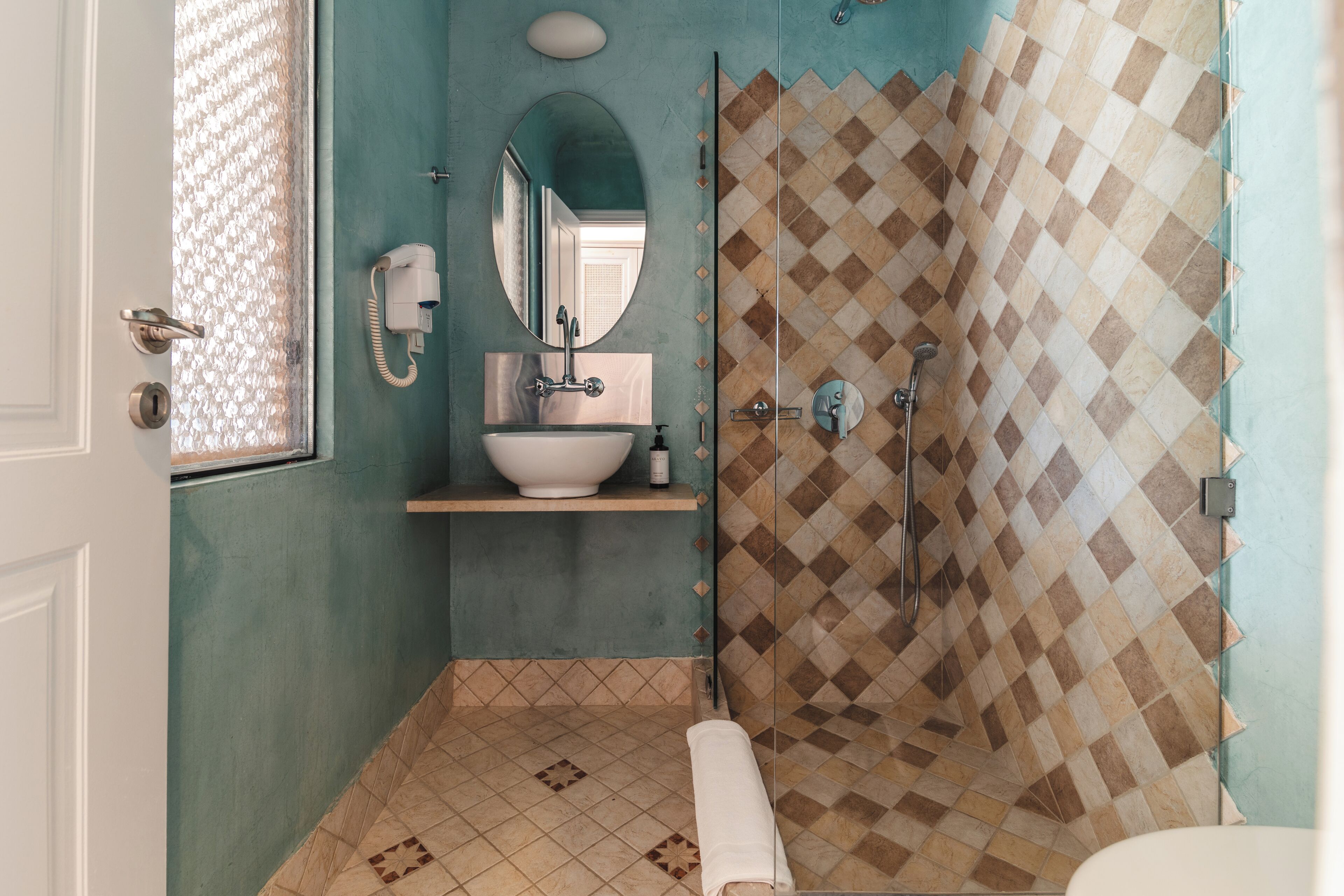 A bathroom with a sink, mirror, and shower.