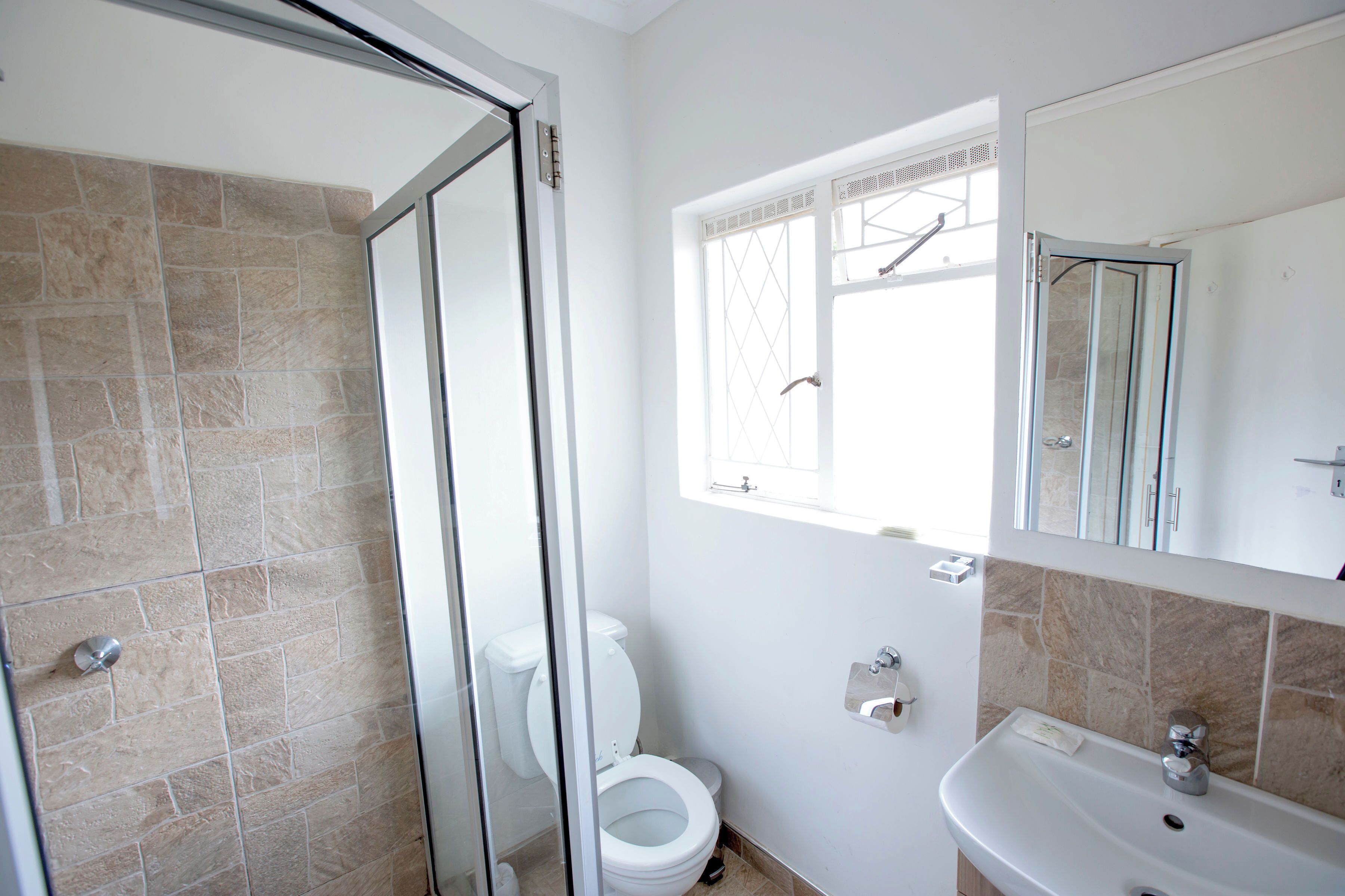 A bathroom with a shower, toilet, and sink.