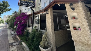 L’entrée d’un hôtel, avec une enseigne indiquant : « Serenity Suite Hotel ».