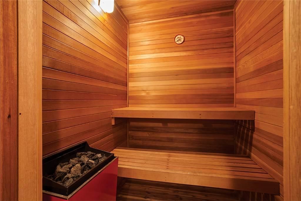 A wooden sauna with benches and a firebox.