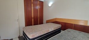 Ein Schlafzimmer mit einem Bett, einem Kleiderschrank und einer Wandleuchte.