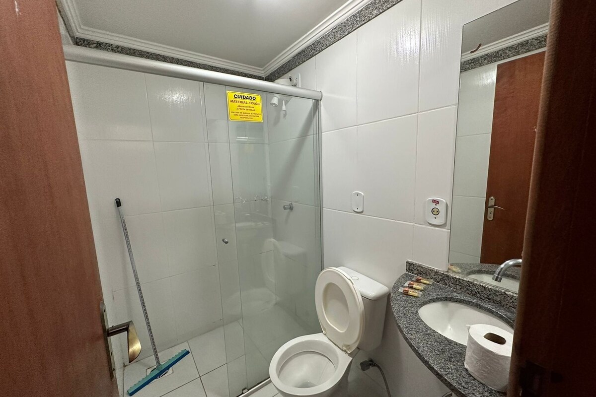 Ein Badezimmer mit Dusche, Toilette, Waschbecken und Spiegel.