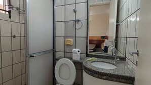 Une salle de bain avec des toilettes, un lavabo et un miroir.