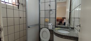 Ein Badezimmer mit Toilette, Waschbecken und Spiegel.