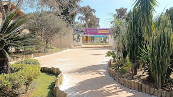 Uma trilha pavimentada conduz a um edifício com uma placa que diz 'Siga em Frente Espaço Kids'.