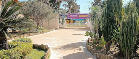 A paved pathway leading to a building with a sign that reads 'Siga em Frente Espaço Kids.'