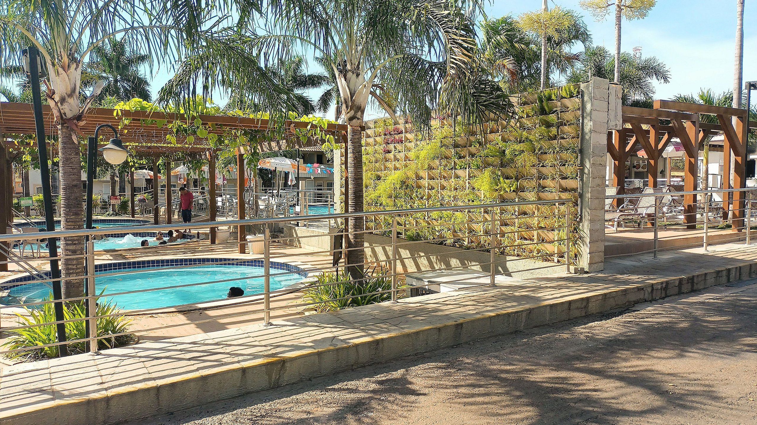A pool area with lounge chairs and a pergola.