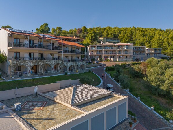 A multi-story hotel with balconies, stone arches, and a rooftop terrace.