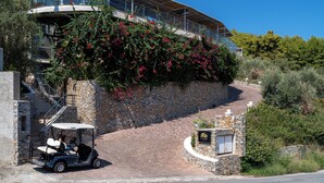 Un edificio moderno con una pared de piedra y un carrito de golf estacionado al frente.