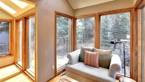 Una habitación acogedora con un gran ventanal, un sofá y una lámpara.