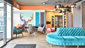 Un intérieur moderne avec un canapé de couleur turquoise, des chaises colorées et une grande sculpture de cerf.