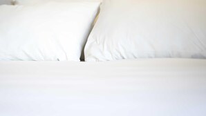 Un lit avec une literie et des oreillers blancs.