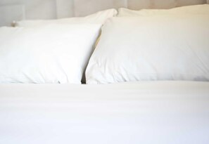 A bed with white bedding and pillows. - B&B HOTEL Le Havre Centre (Le Havre)