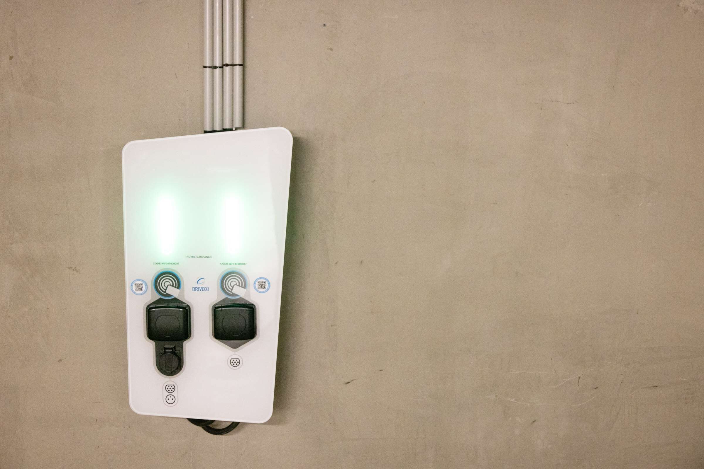 Panel de control en la pared con dos botones negros e indicadores iluminados, probablemente para los servicios de la habitación.