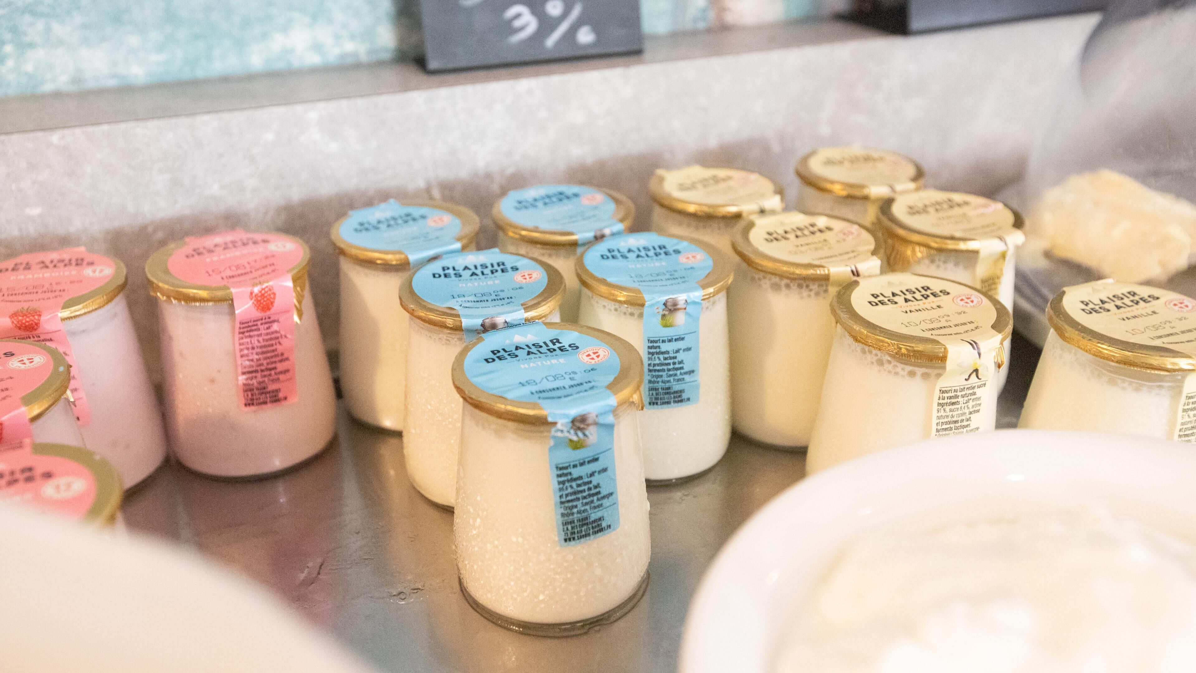 Several jars of dairy products with labels, arranged on a counter.