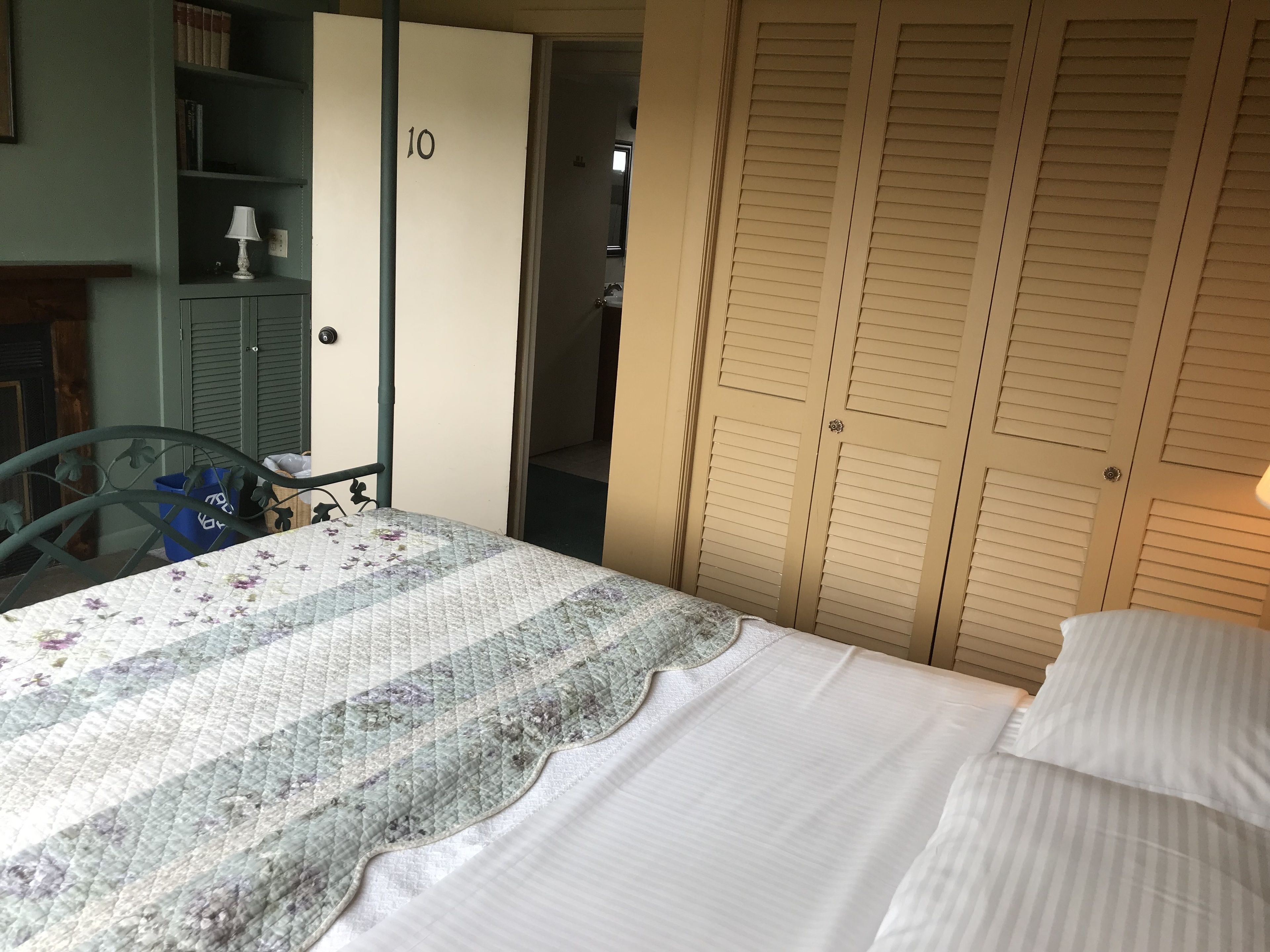 Un dormitorio con cama, armario y escritorio.