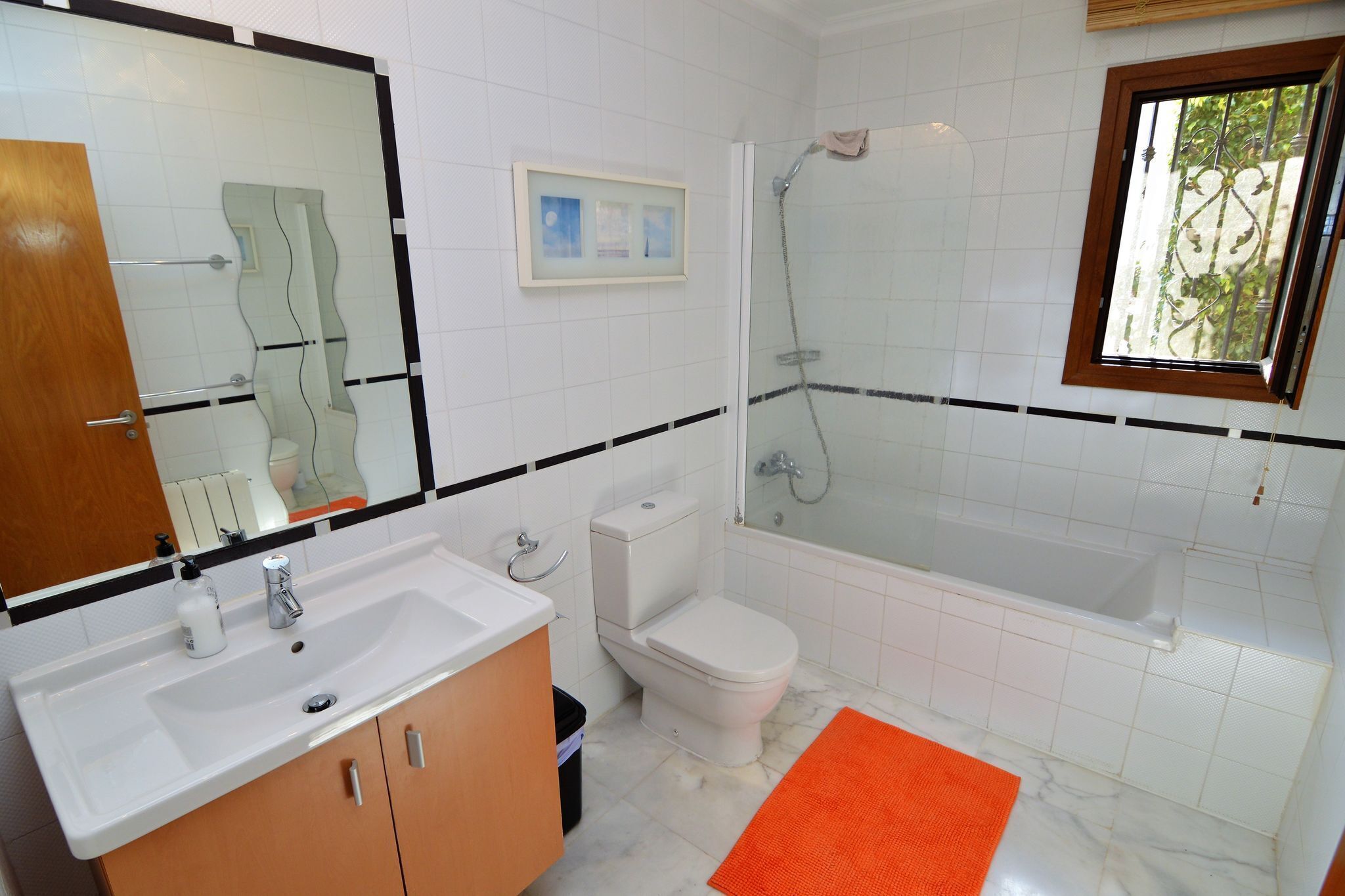 A bathroom with a white sink, toilet, and bathtub.