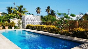 A rectangular swimming pool with clear blue water, surrounded by a tiled deck. - Casa Del Sol Tobago (Crown Point)