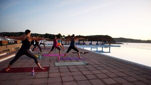A group of people performing yoga on mats by a poolside. - 9 Bahias Condos (Santa María Huatulco)