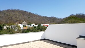 A rooftop terrace with a view of a hillside and buildings. - 9 Bahias Condos (Santa María Huatulco)