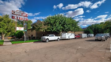 Un motel avec une enseigne, un camionnette blanche et une remorque.