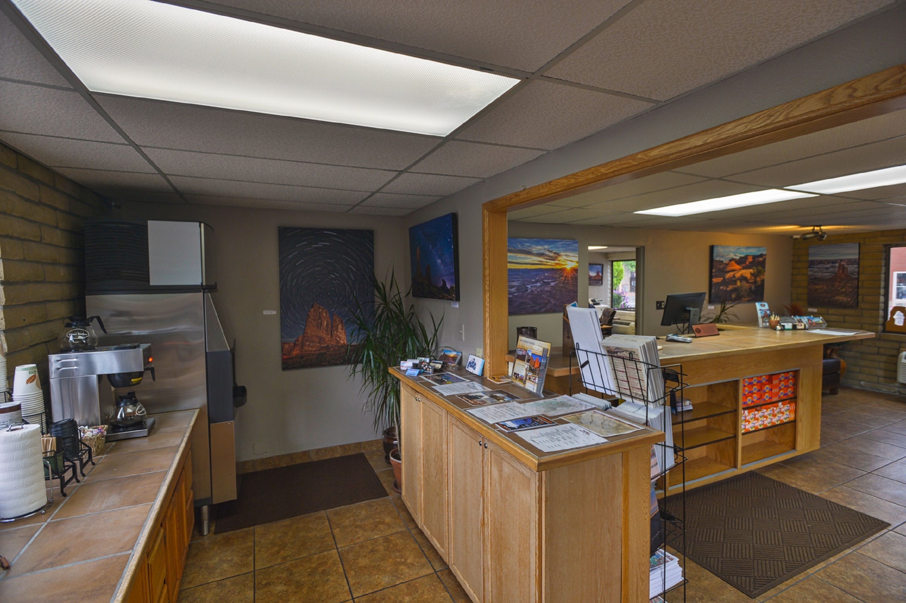 A reception area with a coffee machine, a refrigerator, and a counter with informational brochures.