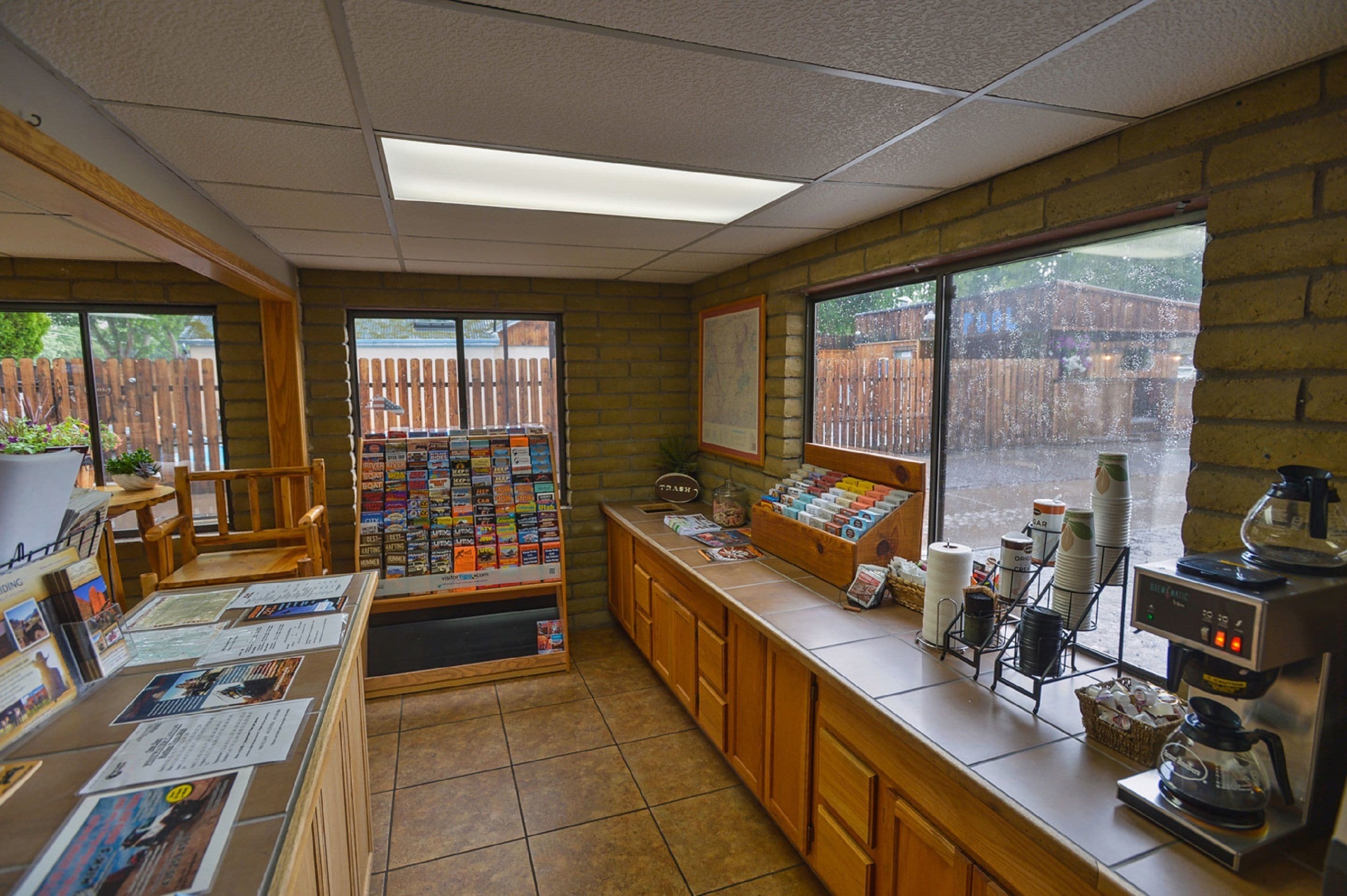 A coffee shop with a counter, coffee machines, and a menu board.