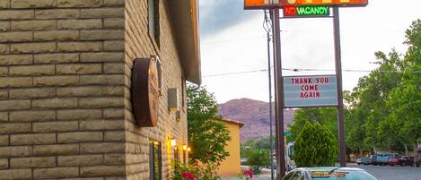 A rustic motel sign with a 'No Vacancy' notice and a 'Thank You Come Again' sign.