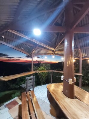 An outdoor patio area with wooden benches and a metal roof structure. - Bella Vista Lodge, Monteverde Costa Rica (Monteverde)