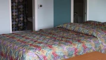 Une pièce comprenant un lit, une table et une porte donnant sur une salle de bain.