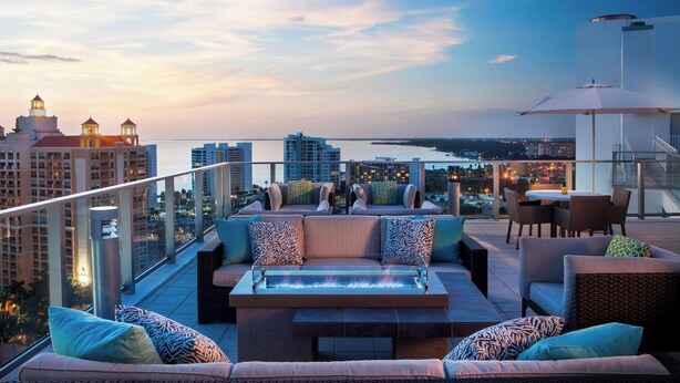 A rooftop terrace with a fire feature, seating area, and a view of the city skyline. - The Westin Sarasota (Sarasota)