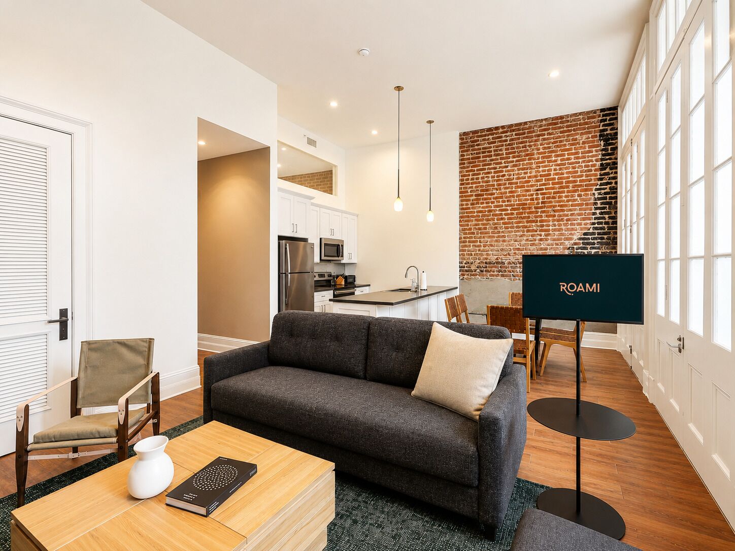 A modern living room with a sofa, coffee table, and a television labeled 'ROAMI' in the background.