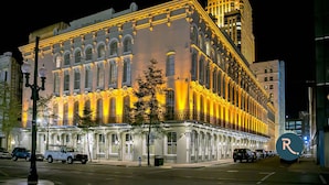 A historic building with ornate architecture and a prominent 'R' sign, likely a hotel. - Roami at Factors Row (New Orleans)