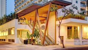 A modern hotel with a prominent outdoor staircase, large windows, and a balcony area. - The Laylow Waikiki, Autograph Collection (Honolulu)