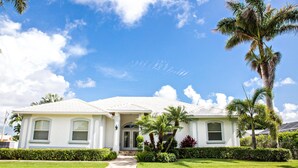 A two-story house with a white exterior, a front porch, and a well-maintained lawn. - 1372 Leland Way (Marco Island)