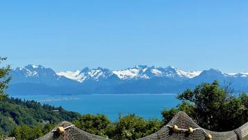 A mountainous landscape with a lake and snow-capped peaks in the background.
