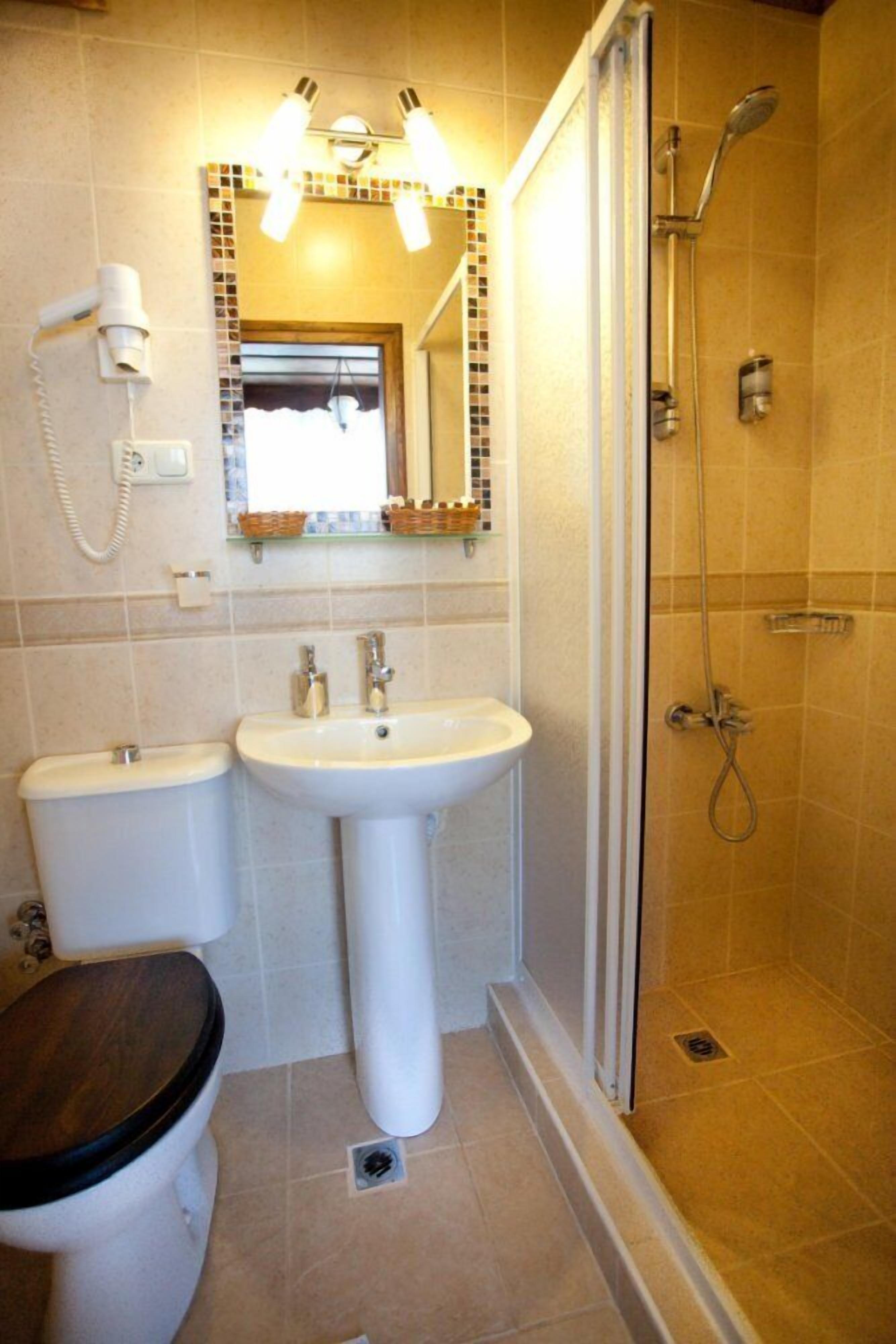 Une salle de bain avec des toilettes, un lavabo et une douche.