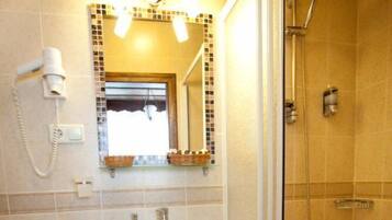 A bathroom with a toilet, sink, and shower.